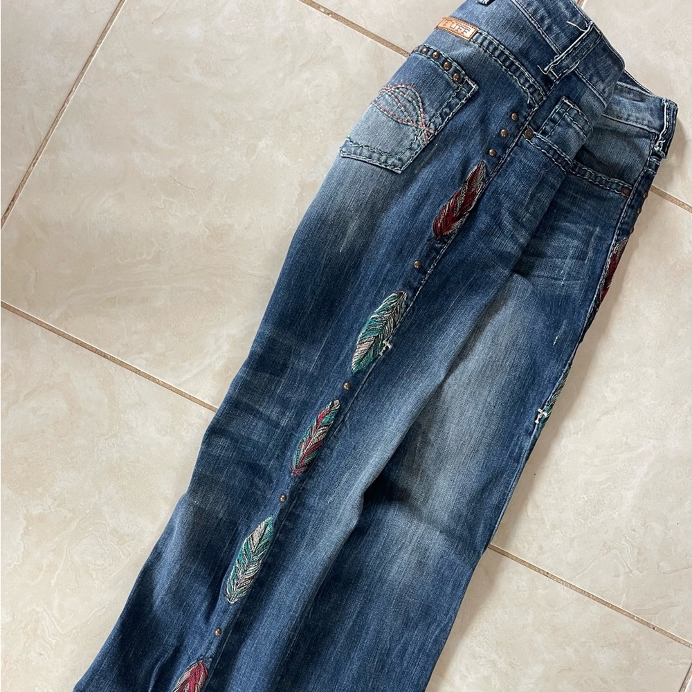 Pair of Cowgirl tuff Brave Wings jeans 28x33